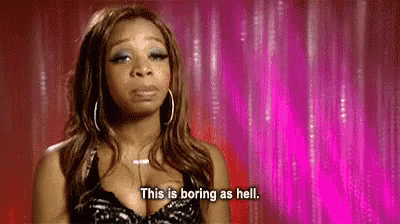 a woman is saying `` this is boring as hell '' in front of a pink curtain .