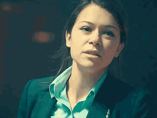 a close up of a woman 's face wearing a blue jacket and a blue shirt