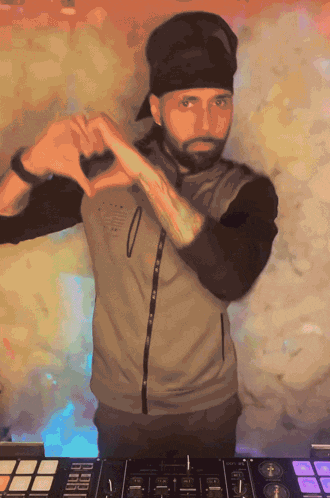 a man making a heart shape with his hands while standing in front of a mixer
