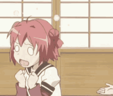 a girl with red hair is sitting at a table with her mouth open