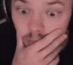 a person is covering their mouth with their hand .