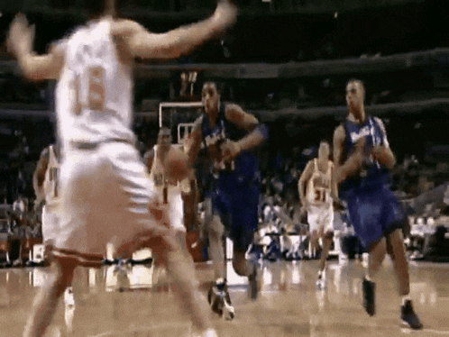 a group of basketball players are playing a game on a court and one player has the number 18 on his jersey