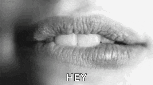 a black and white photo of a woman 's lips with the words `` hey '' written next to them .