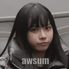 a woman with long black hair is making a funny face while wearing a jacket .
