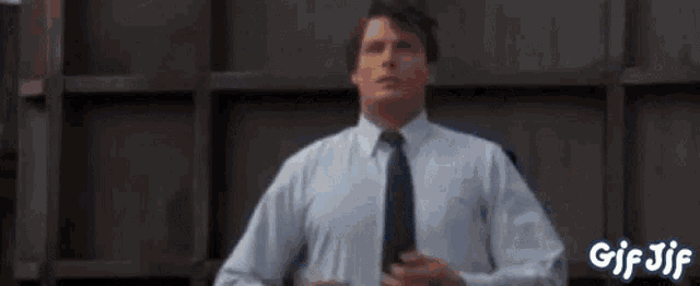 a man in a white shirt and tie is getting ready to go to work .