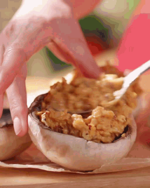 a person is filling a mushroom with a spoon of food