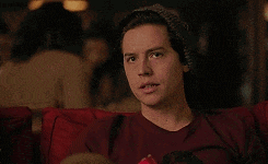 a young man wearing a beanie is sitting on a couch .