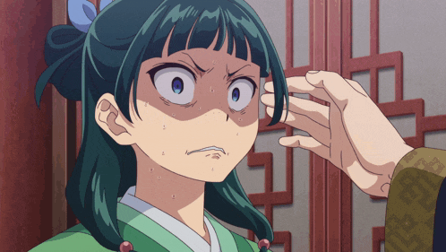 a person touching a girl 's forehead with their hand