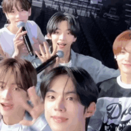 a group of young men are posing for a picture with a microphone .