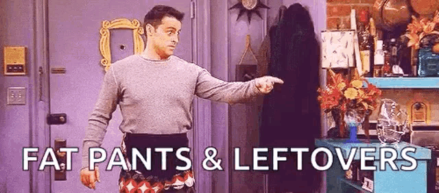 a man wearing fat pants and leftovers is pointing at a door .