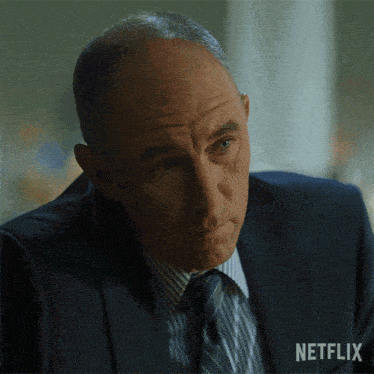 a man in a suit and tie with a netflix logo on the bottom