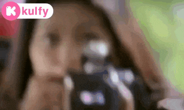 a woman is taking a picture of herself with a camera in a blurry photo .