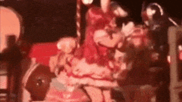 a woman in a pink dress is dancing on a stage with a cane .