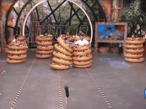 a bunch of donuts are stacked on top of each other in front of a sign that says " hunt "