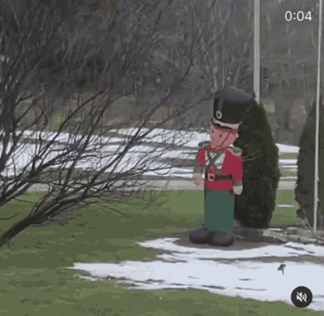 an inflatable nutcracker is standing in a snowy yard