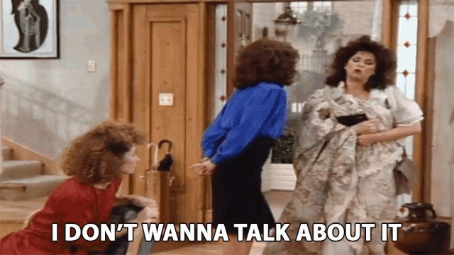 three women standing in front of a door with the words i don 't wanna talk about it