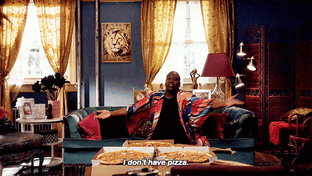 a man is sitting on a couch with boxes of pizza and says i don 't have pizza