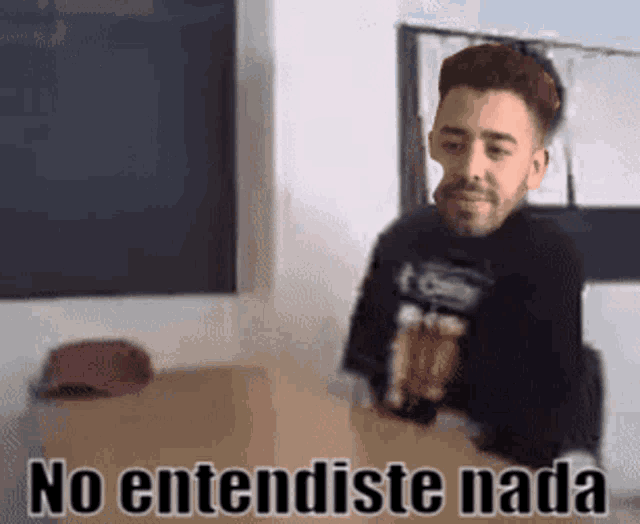 a man in a black shirt is holding a cardboard box with the words no entendiste nada written on it