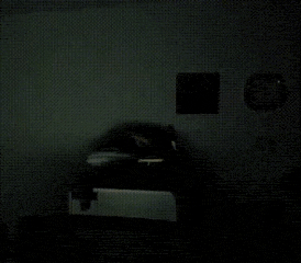 a blurry picture of a person standing in a dark room with a laptop .