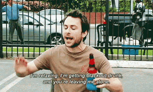 a man in a brown shirt is holding a bottle of soda and says i 'm relaxing