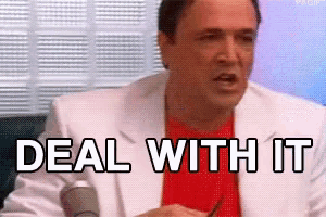 a man in a white suit and red shirt is talking into a microphone .
