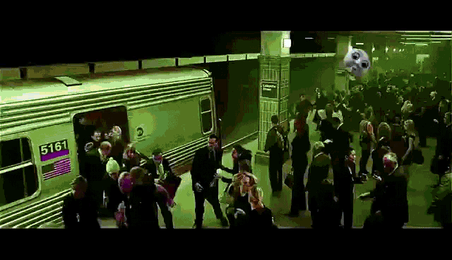 a crowd of people are waiting to board a train number 5161