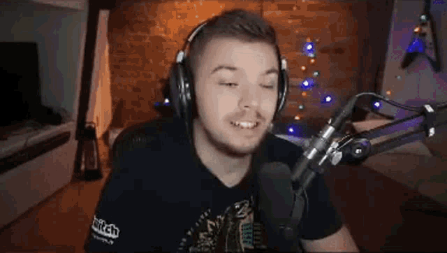 a man wearing headphones and a microphone is sitting in front of a christmas tree .