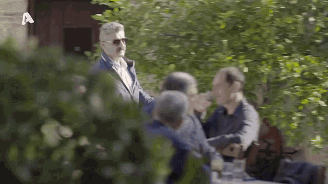 a group of men are sitting at a table with a sign that says a.