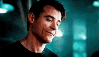 a close up of a man 's face with his eyes closed and a smile on his face .