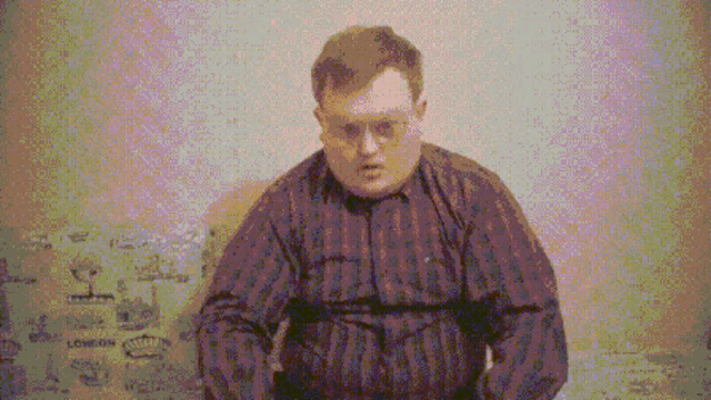 a pixelated image of a man sitting in front of a wall that says london on it