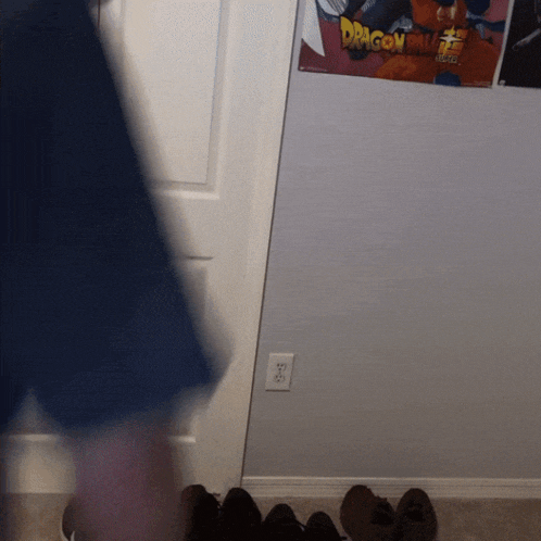 a dragon ball poster hangs on a wall next to a pair of shoes