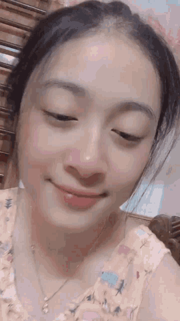 a close up of a woman 's face with her eyes closed and a smile on her face