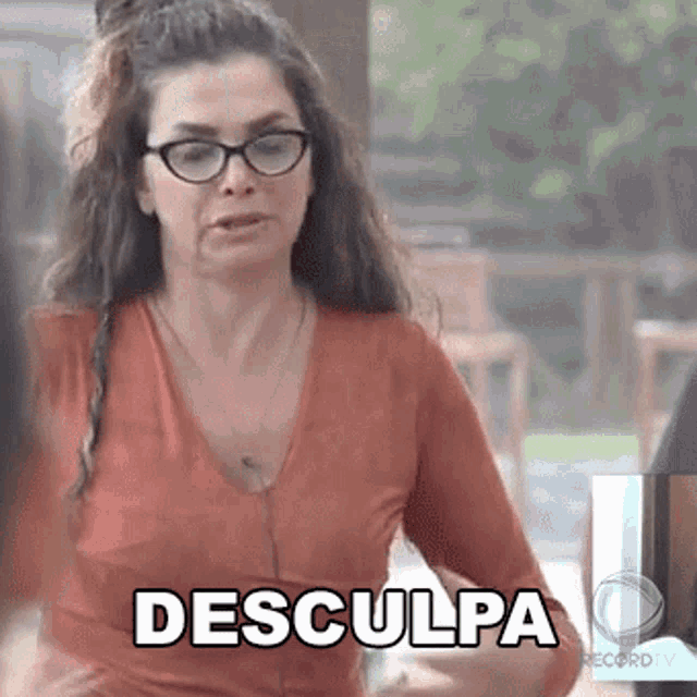 a woman wearing glasses and a red shirt is making a funny face and saying desculpa .