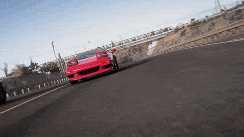 a red sports car is driving down a highway