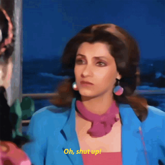 a woman in a blue jacket and a pink scarf says oh shut up