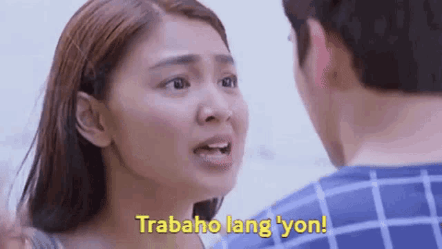 a man and a woman are looking at each other and the woman is saying `` trabaja lang yon '' .