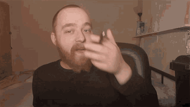 a man with a beard is sitting in a chair smoking a cigar