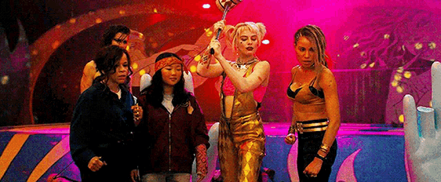 a group of women are standing next to each other on a stage holding a microphone .