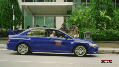 a blue car is parked in front of a building that says full on the bottom