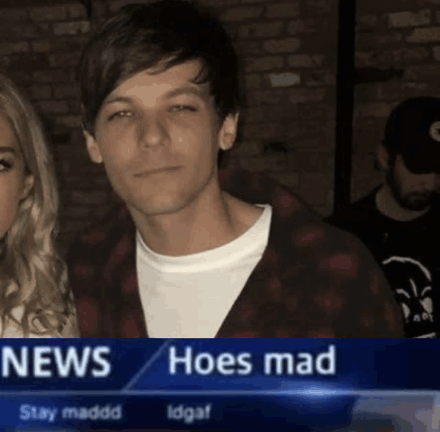 a man in a plaid shirt stands in front of a news screen that reads hoes mad