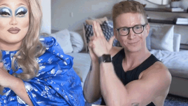 a man wearing glasses is sitting next to a woman wearing makeup