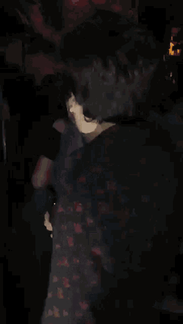 a man in a floral shirt is holding a glass of beer