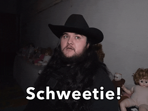 a man with long hair and a cowboy hat says schweetie