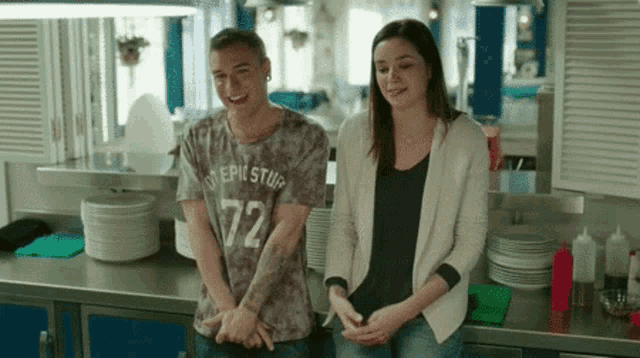 a man wearing a shirt with the number 72 on it is sitting next to a woman