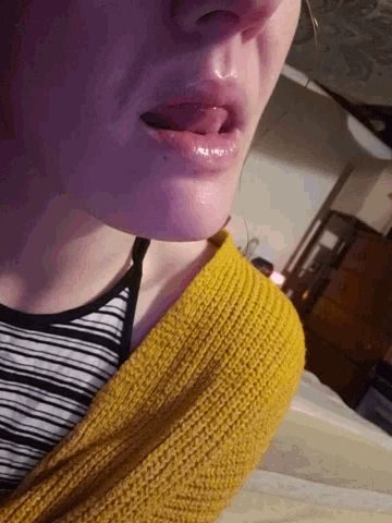 a woman wearing a yellow sweater and a black and white striped top