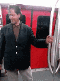 a man in a black jacket is standing next to a red train