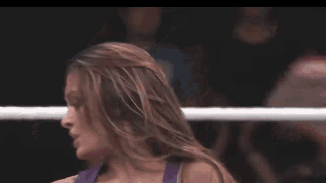 a woman is standing in a wrestling ring .