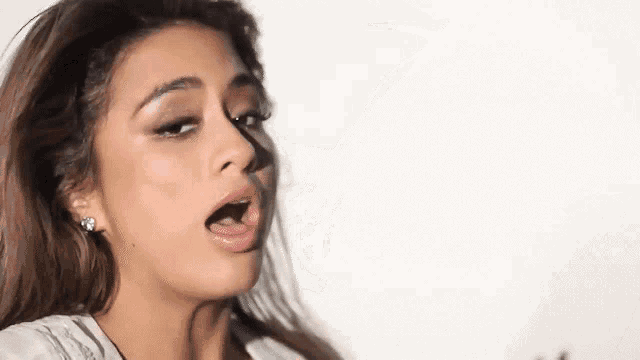 a close up of a woman with her mouth open .