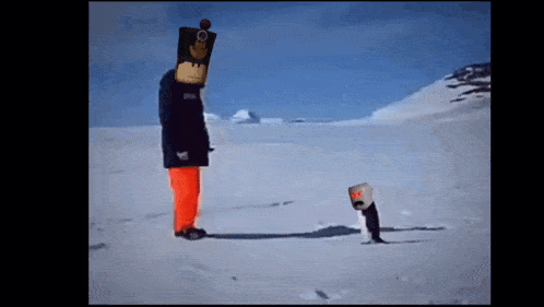 a man in a monkey mask is standing in the snow next to a penguin .