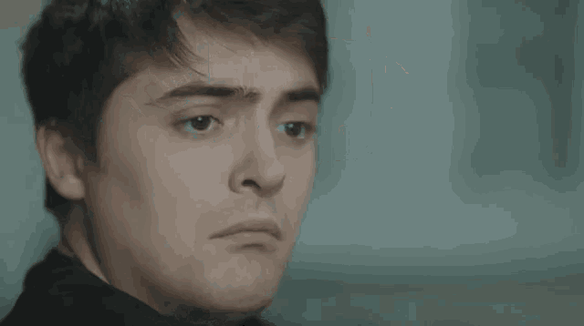 a close up of a man 's face with his eyes closed in a blurry photo .